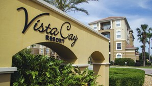 A sign for Vista Cay Resort with a clear archway and lush greenery. - 3BD 2BA Condo Sleeps 6 Gold RVC30533 Bedroom RHOF (Orlando)