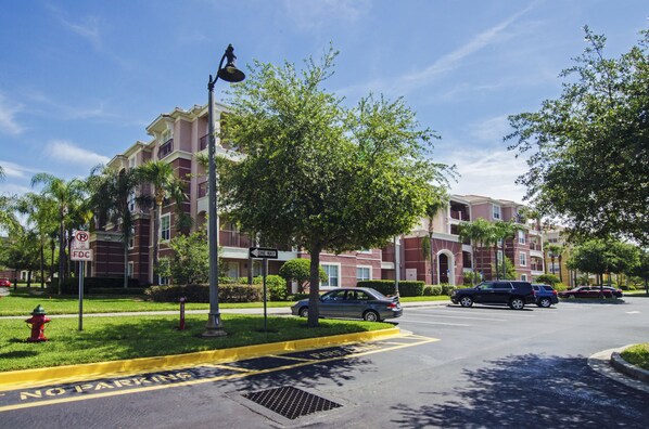 A multi-story building with a red brick facade, a grassy area with a fire hydrant, and a 'No Parking' sign. - 3BD 2BA Condo Sleeps 6 Gold RVC30533 Bedroom RHOF (Orlando)