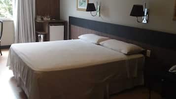 Una habitación de hotel con una cama grande, un escritorio, una silla y un teléfono.