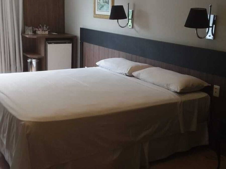 Una habitación de hotel con una cama grande, un escritorio, una silla y un teléfono.
