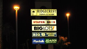 Een bord met diverse bedrijfsnamen, waaronder Ridgecrest Town Centre, Stater Bros, Big Lots, Big 5 Sporting Goods, Marshalls en Jo-Ann Fabrics and Crafts.