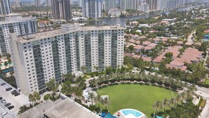 A high-rise building with multiple floors, a central courtyard with a pool, and surrounding residential buildings. - Ocean Reserve Condominium (Sunny Isles Beach)