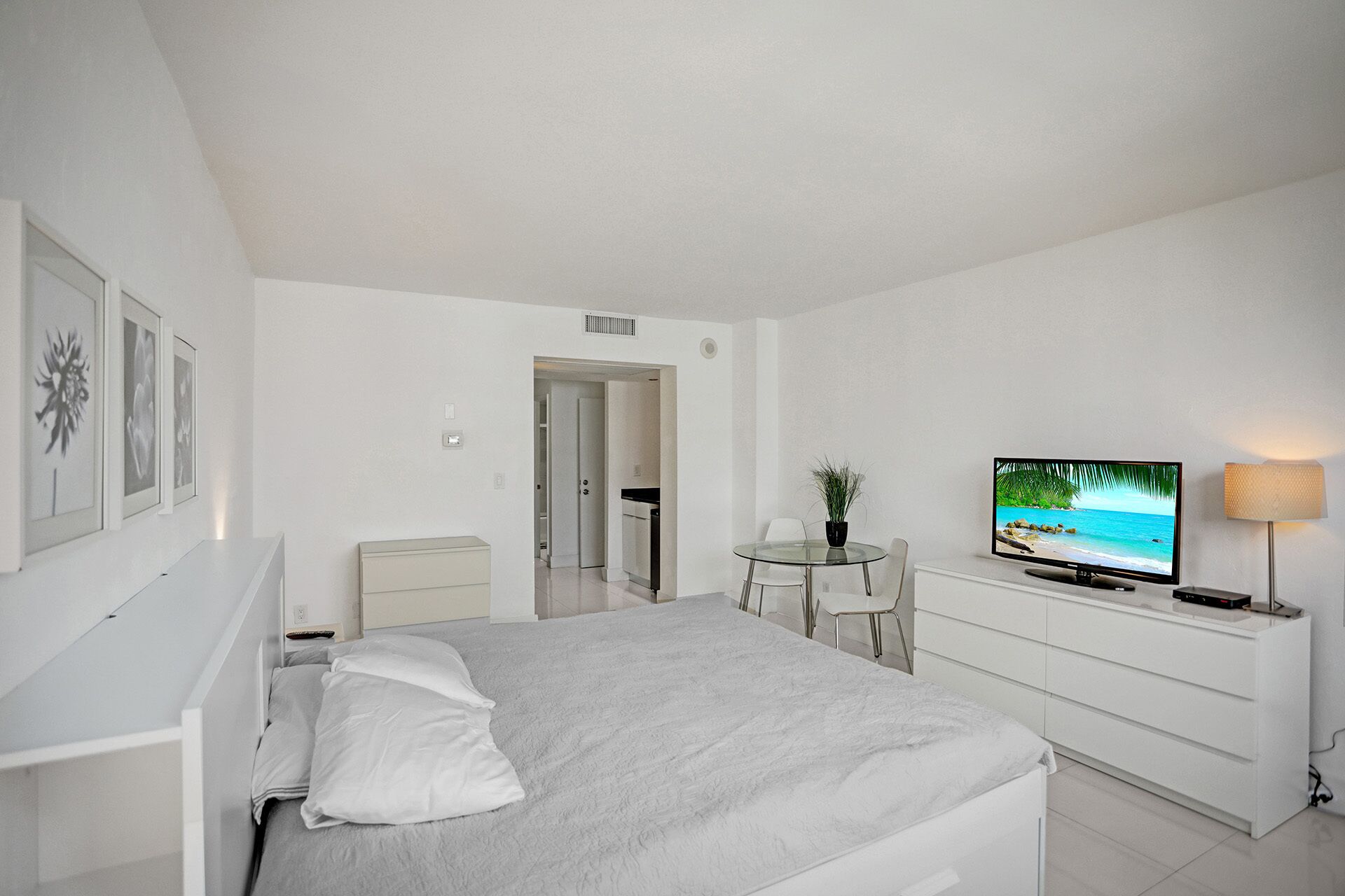 Une chambre à coucher moderne, équipée d’un lit, d’une télévision, d’un bureau et d’une chaise.