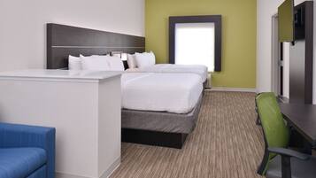 A hotel room with a bed, a desk, a chair, and a television.