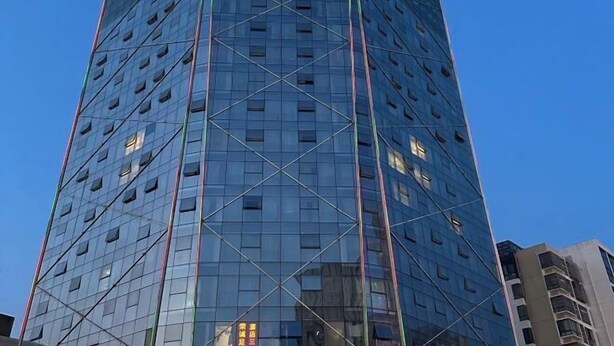 A tall, modern glass building with a grid-like facade and visible windows. - Vienna International Hotel (Changzhou Hutang) (Changzhou)
