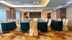 A conference room with a long table, white chairs, and a carpeted floor. - Vienna International Hotel (Changzhou Hutang) (Changzhou)