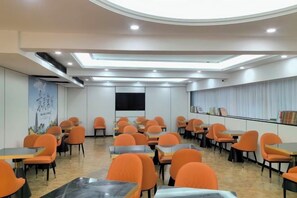 A conference room with multiple tables and chairs, a large screen, and a ceiling with recessed lighting. - Vienna International Hotel (Changzhou Hutang) (Changzhou)