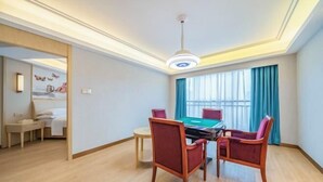A hotel room with a pool table, two chairs, a bed, and a window with curtains. - Vienna International Hotel (Changzhou Hutang) (Changzhou)