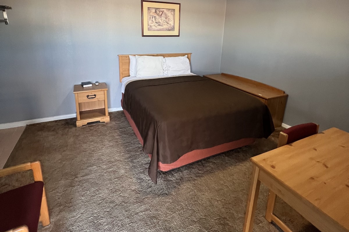 Ein Schlafzimmer mit Bett, Nachttisch und Schreibtisch.