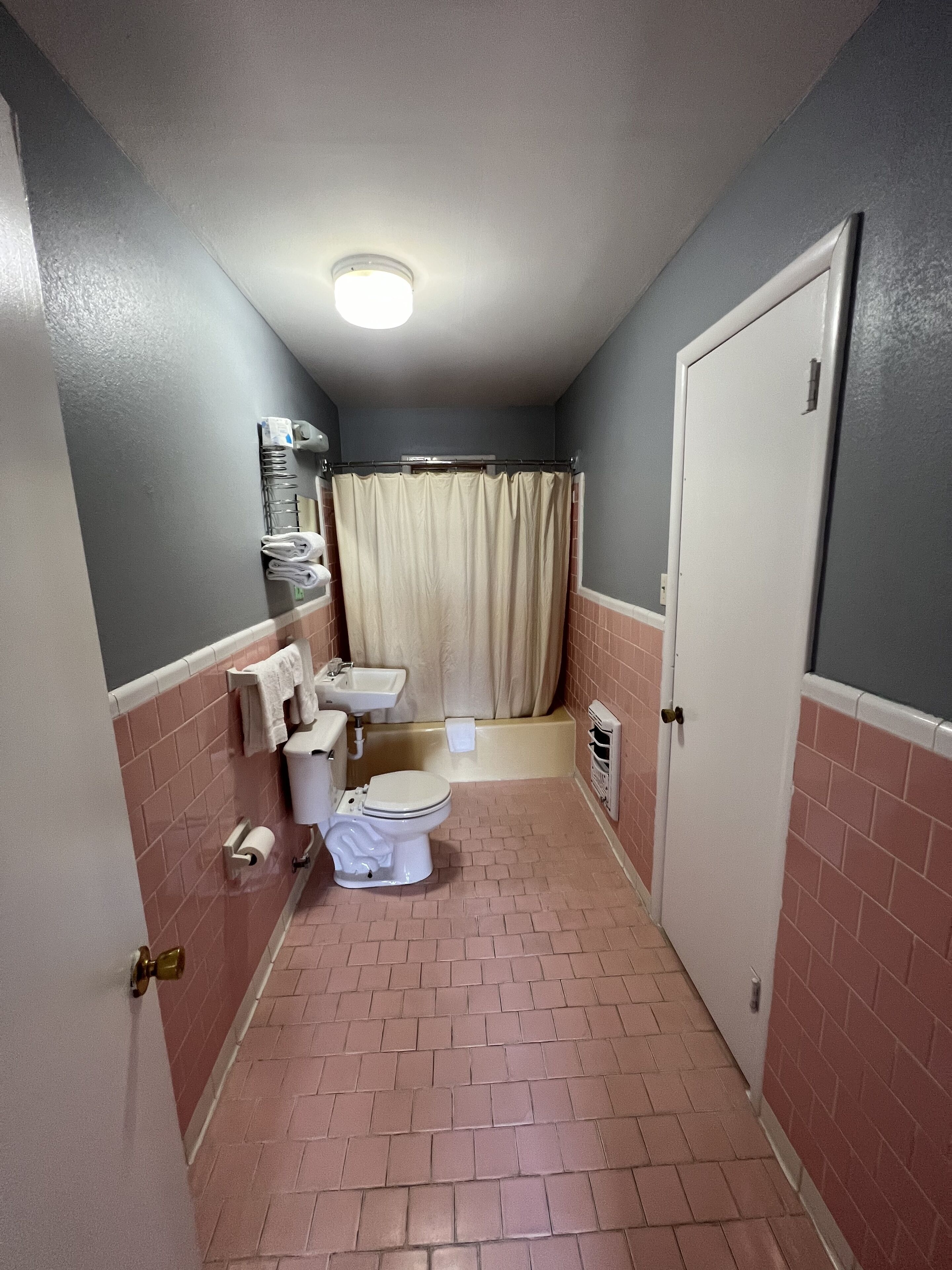 Une petite salle de bain comprenant des toilettes, un lavabo et un espace douche.