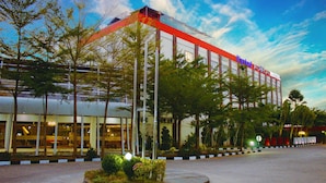 Un hotel con un diseño arquitectónico moderno, que destaca por un esquema de color rojo y blanco y un fachada de vidrio.