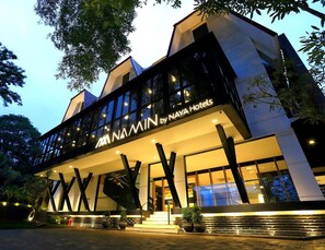 A modern hotel with a prominent 'NAYA Hotels' sign, featuring a unique architectural design with angular lines and large windows. - Hotel Namin (Bandung)
