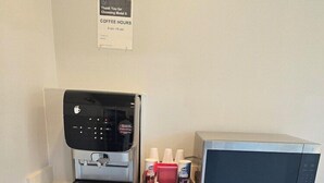 A kitchenette with a coffee machine, microwave, and condiment dispensers. - Americas Best Value Inn Downtown (Los Angeles)