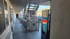 A corridor with a vending machine and a security kiosk. - Americas Best Value Inn Downtown (Los Angeles)