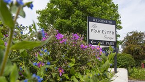 A welcome sign for The Froster George Car Park surrounded by lush greenery and flowers. - The Frocester (Stonehouse)