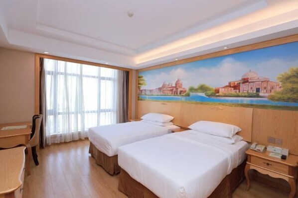 A hotel room with two beds, a desk, a chair, a nightstand, and a painting on the wall. - Vienna International Hotel (Shanghai Songjiang Development Zone Sports Center Metro Station) (Shanghai)