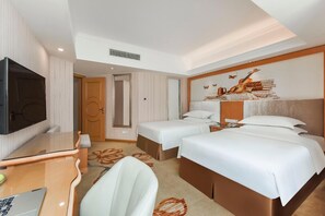 A hotel room with two beds, a desk with a laptop, a television, and a mural on the wall. - Vienna Hotel Guangzhou Panyu Changlong Shiqiao Metro Station (Guangzhou)