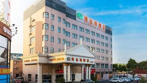 A multi-story hotel with a prominent entrance and a parking area. - Vienna Hotel (Shanghai Jinqiao Park Taierzhuang Road Subway Station) (Shanghai)