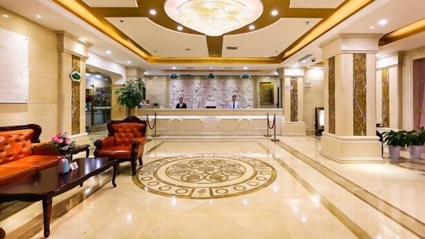 A spacious lobby with a central reception desk, a chandelier, and a circular floor design. - Vienna Hotel (Shanghai Jinqiao Park Taierzhuang Road Subway Station) (Shanghai)