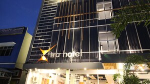 A modern hotel facade with a prominent 'tra hotel' sign, large windows, and a visible entrance. - Xtra Bengkulu Managed by Dafam (Bengkulu)