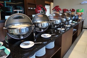 A buffet setup with multiple serving stations, each with a covered bowl and a spoon. - M Premiere Hotel (Bandung)