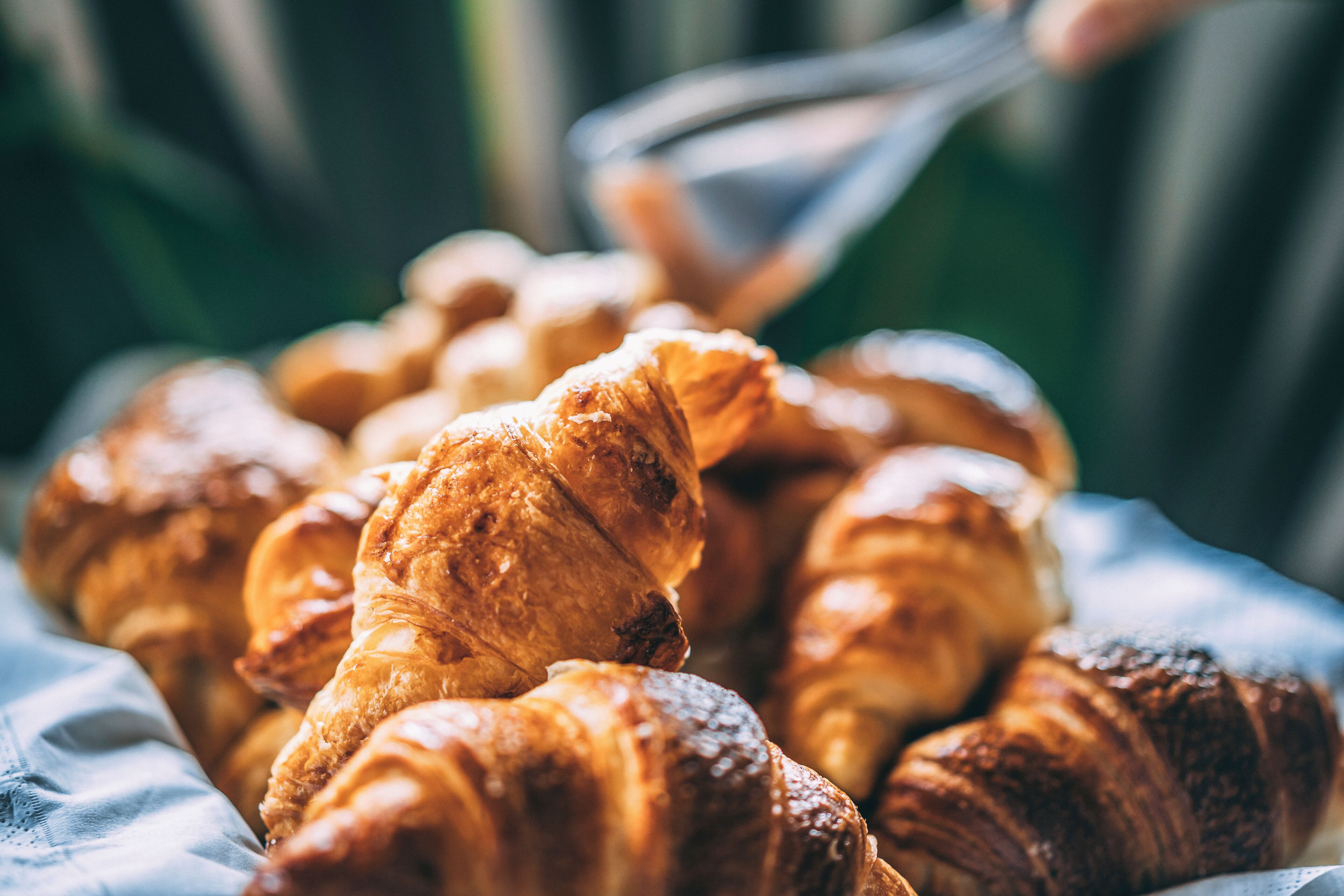 A close-up of a variety of pastries, including croissants, arranged on a surface.