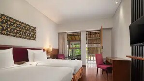Habitación de hotel con dos camas, televisión, escritorio y vista al exterior.