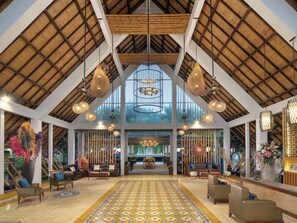 Eine geräumige Lobby mit hohen Decken, großen Fenstern und verschiedenen Sitzgelegenheiten.