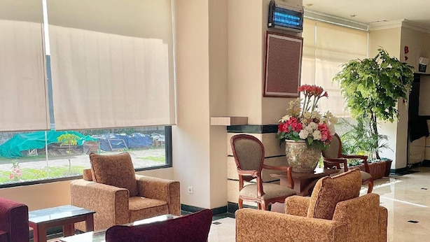 A hotel lobby with seating arrangements, a television, and a view of the outdoors. - Royal Asia Palembang (Palembang)