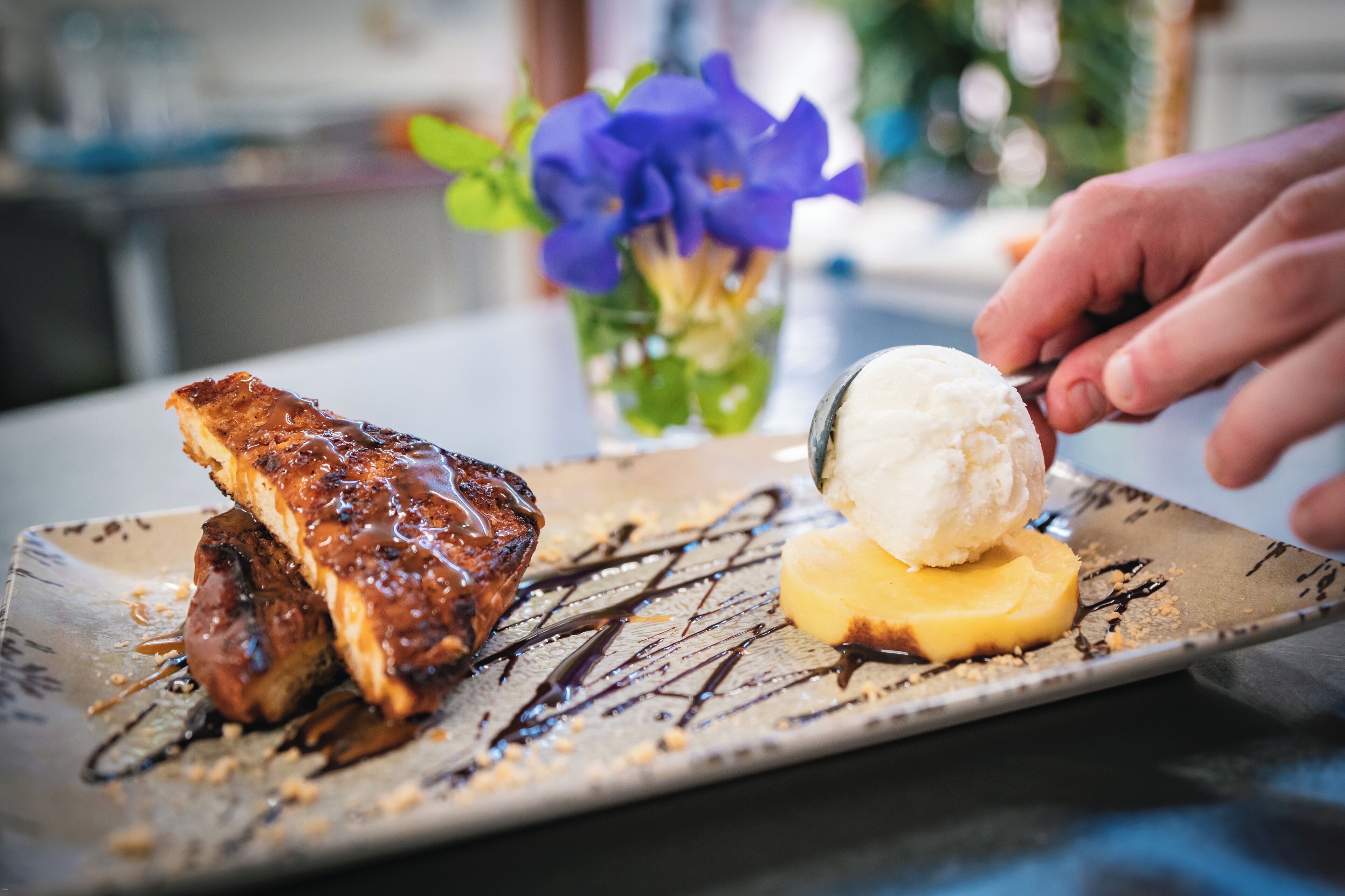 A dessert plate with a piece of cake and a scoop of ice cream on a ceramic plate.