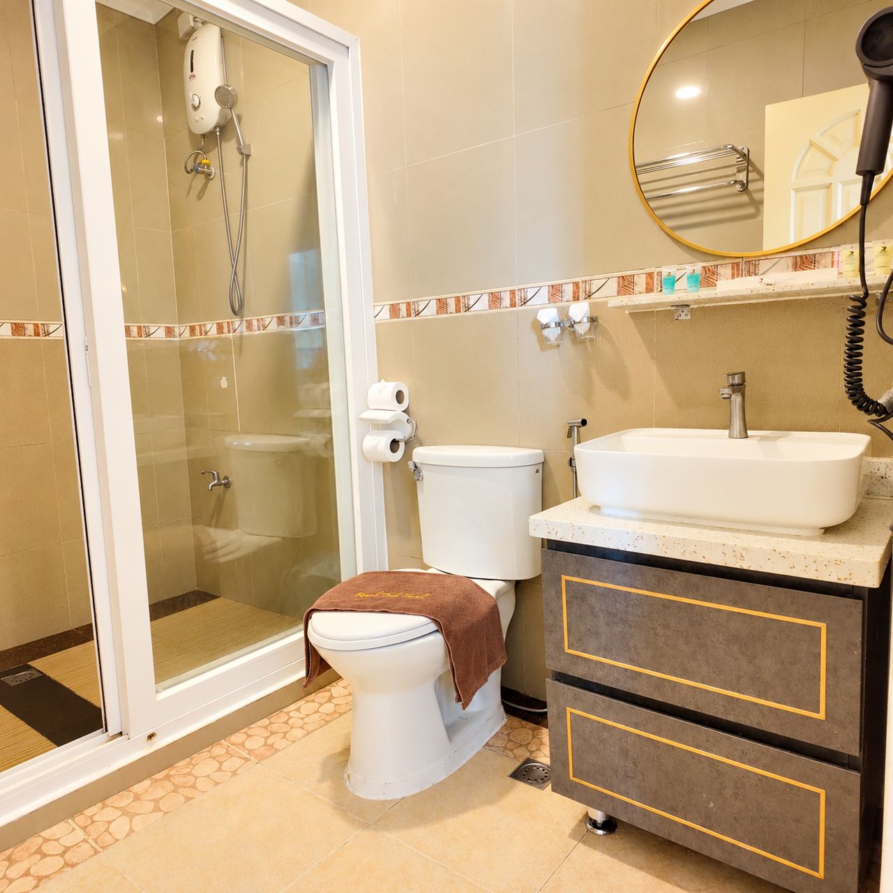 Ein Badezimmer mit Duschkabine, Toilette, Waschbecken und Spiegel.