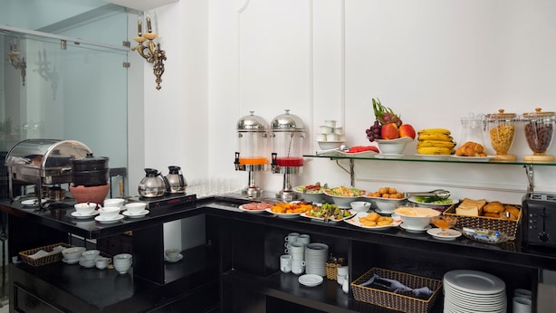 Montaje de bufé con diversos alimentos, máquinas de café y dispensadores de bebidas.