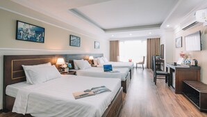 Habitación de hotel con dos camas, un escritorio, una silla y un comedor.