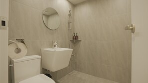 A bathroom with a toilet, sink, mirror, shower, and hand sanitizer. - Jeju Stay (Jeju City)