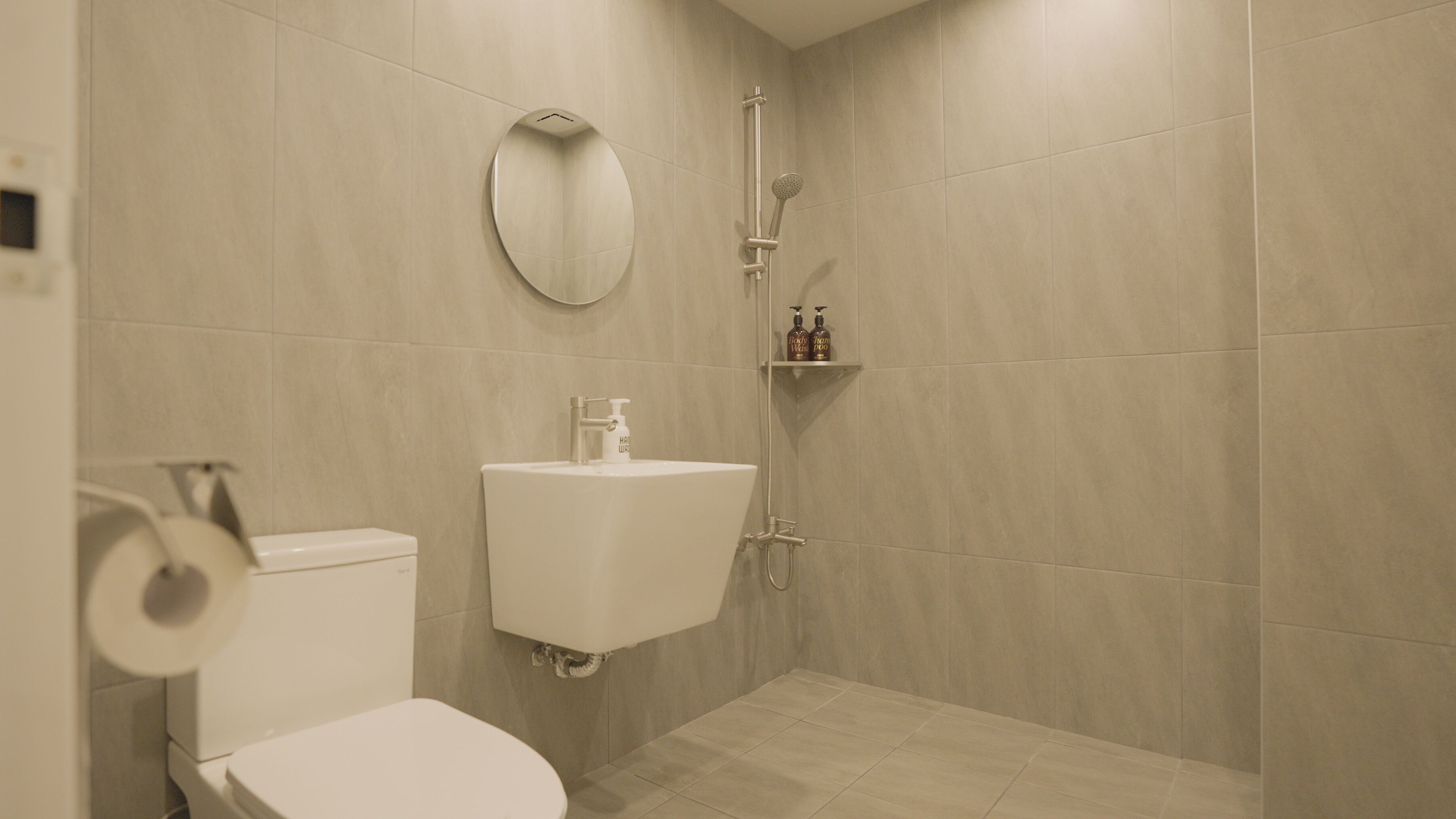 A modern bathroom with a toilet, sink, and shower.