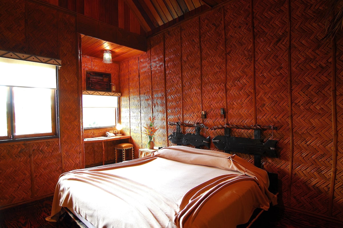 A room with a bed, a desk, and a window.