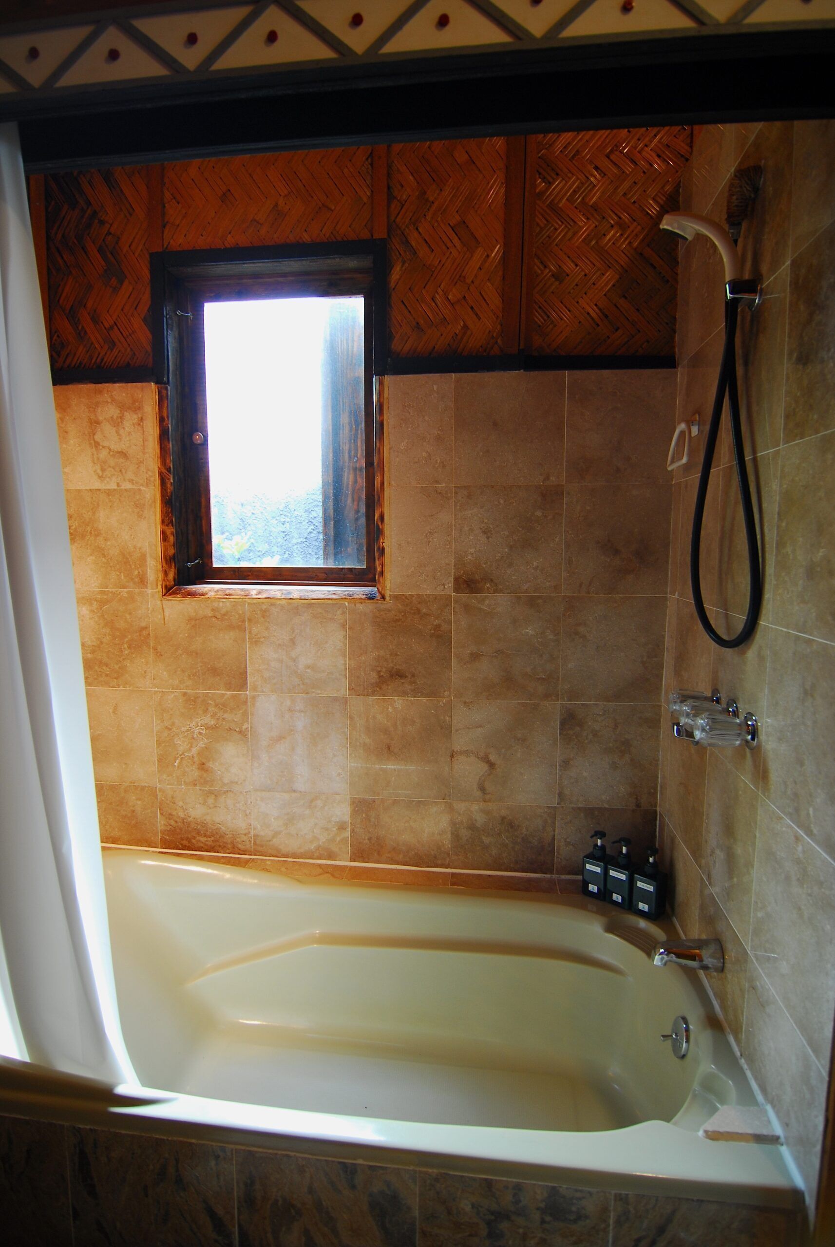 A bathroom with a bathtub, a shower, and a window.