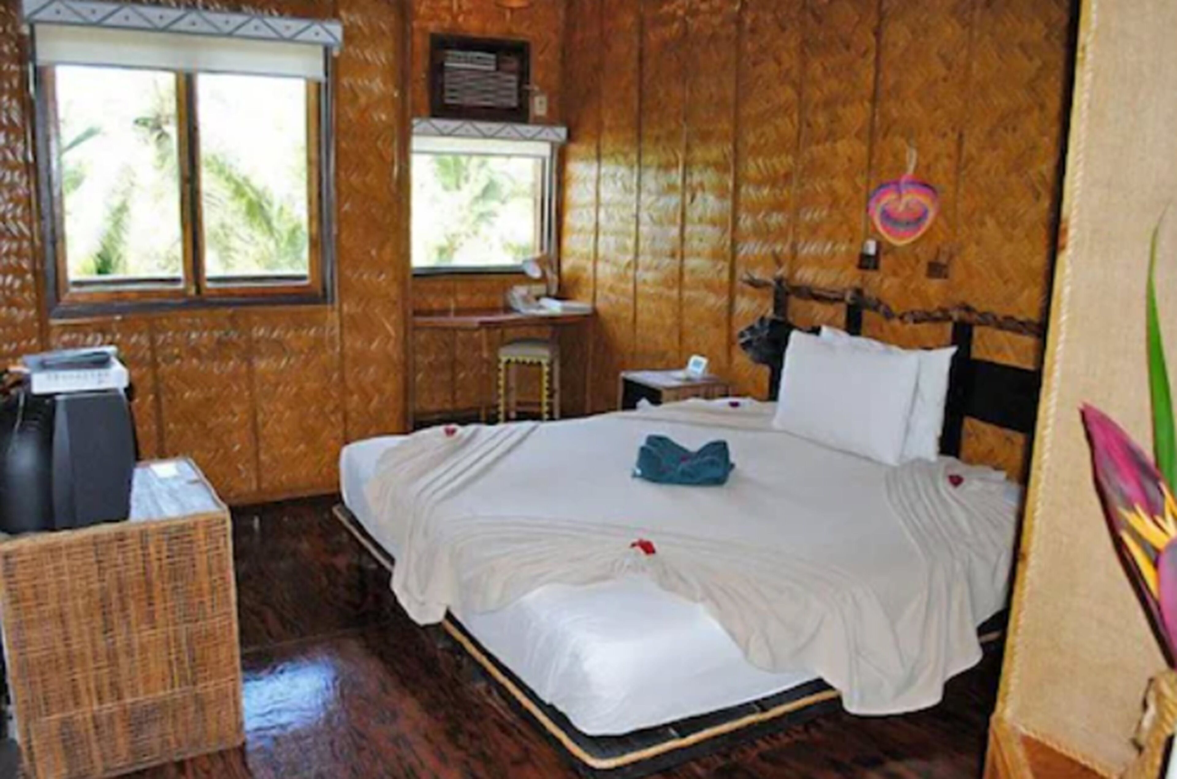 A wooden-paneled room with a bed, a desk, and a window.