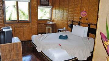 A wooden-paneled room with a bed, a desk, and a window.