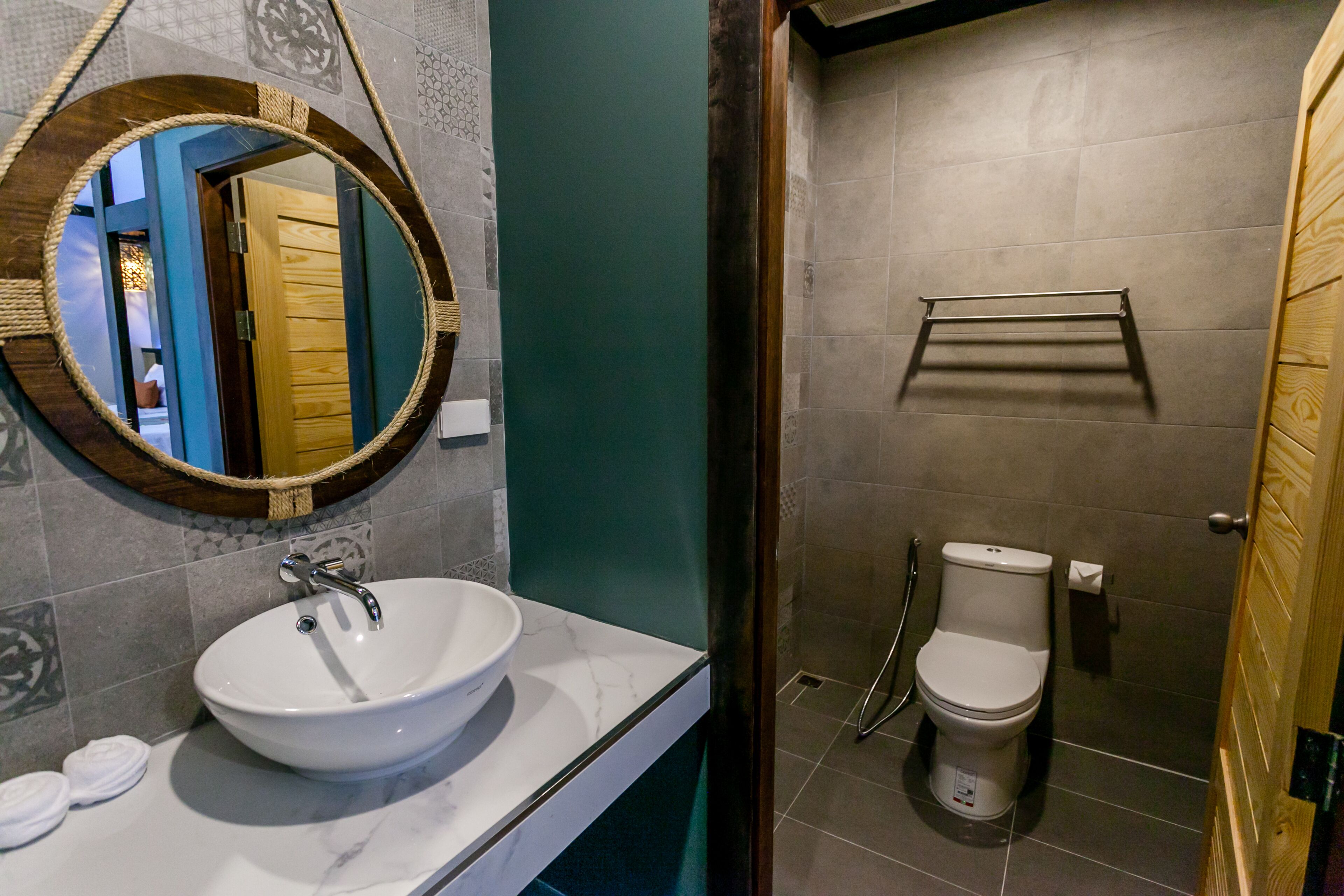 Un baño con lavamanos blanco, espejo y retrete.