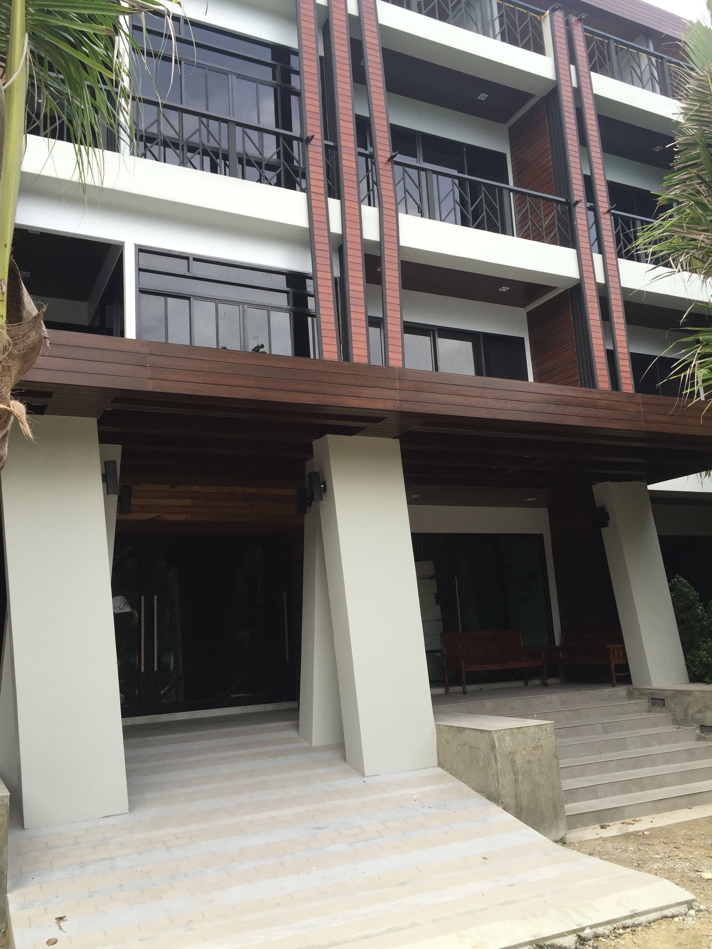 A multi-story building with a modern design, featuring a flat roof and large windows.