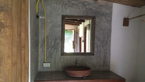 A bathroom with a wooden bench, a sink, and a mirror on the wall. - Sipsongpanna Resort Pai (Pai)