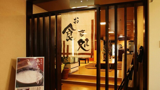 A traditional Japanese interior with tatami flooring, a sliding door with calligraphy, and a poster advertising a local dish. - Capsule Hotel Wellbe Sakae - Caters to Men (Nagoya)