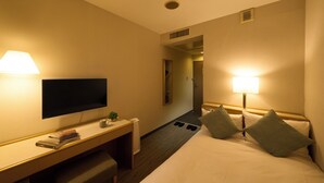 A hotel room with a bed, desk, TV, and lamps. - Hotel Resol Machida (Machida)
