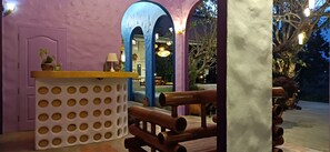 A reception area with a wooden counter, a white decorative panel, and a purple archway.