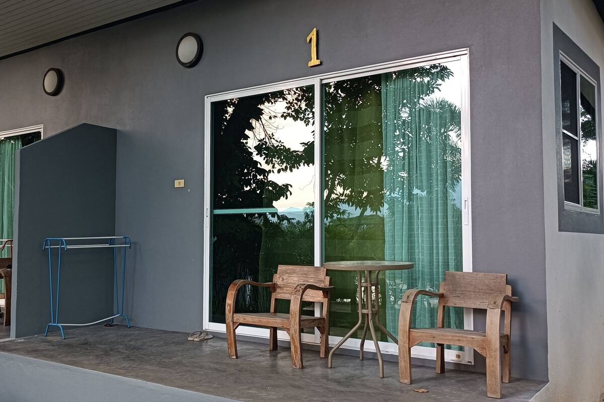 A modern building with numbered doors, large windows, and outdoor seating.