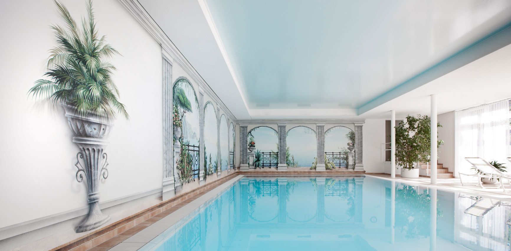 Een binnenzwembad en ligstoelen