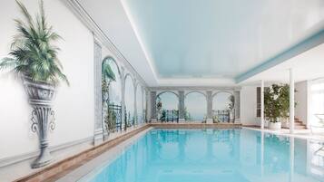 Een binnenzwembad en ligstoelen