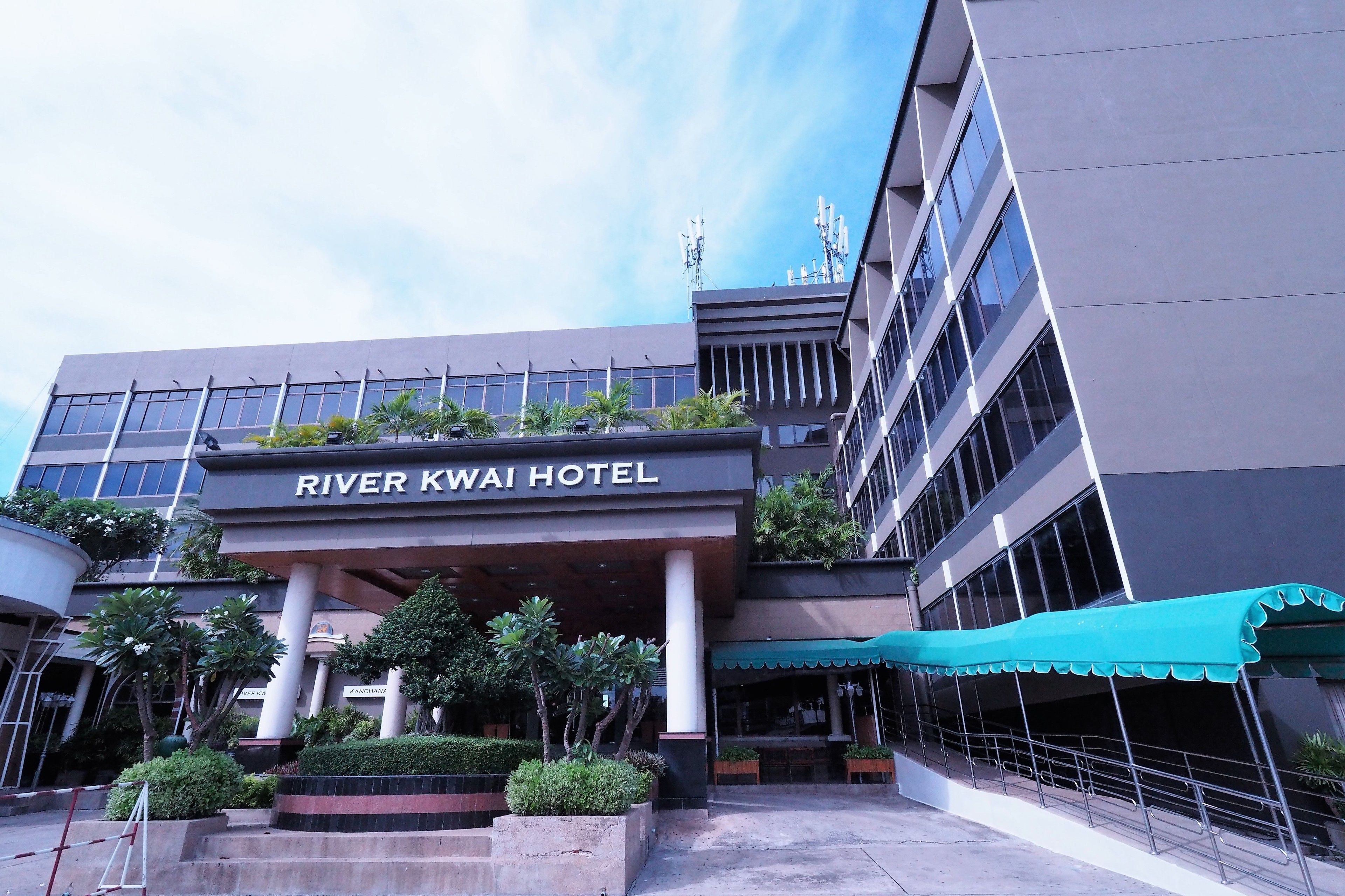 The River Kwai Hotel with a covered entrance, columns, and a sign above the entrance.