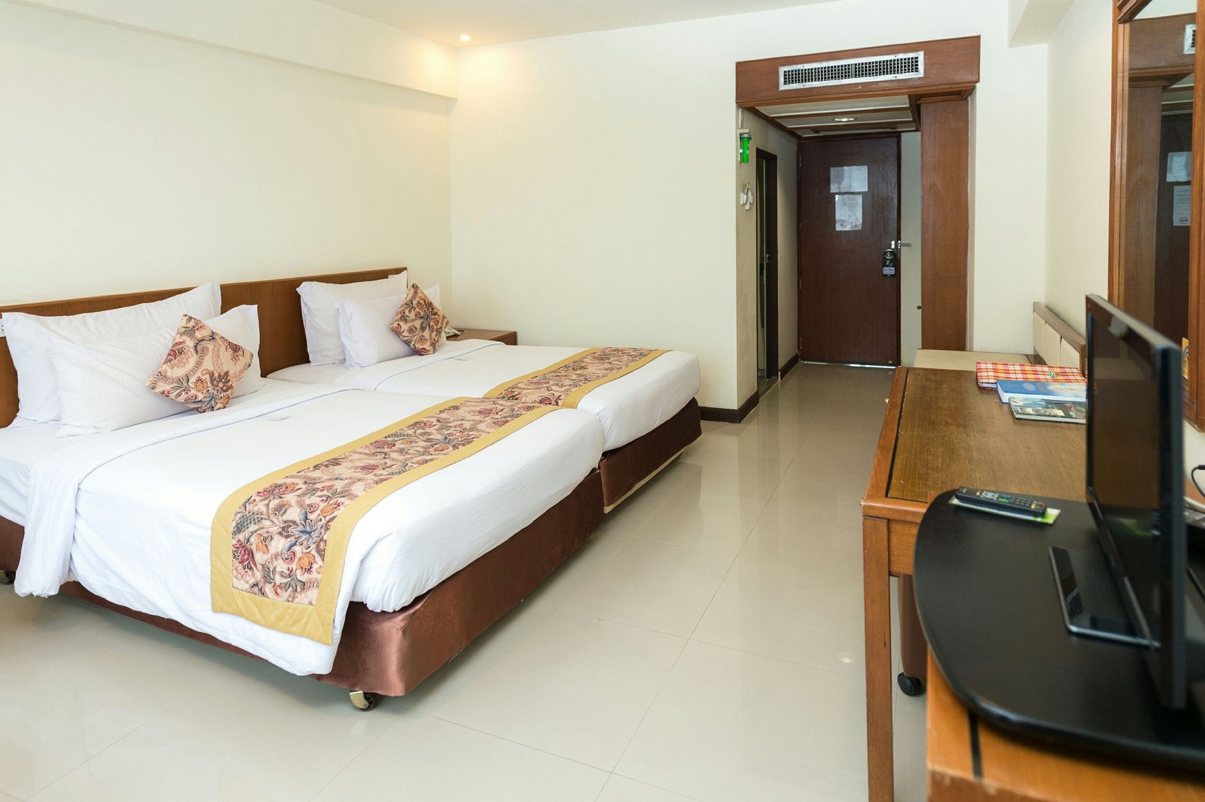 Una habitación de hotel con una cama doble, un escritorio con ordenador y una televisión.